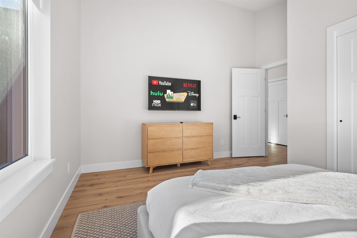Relax with your favorite shows in this bright Queen Bedroom retreat.