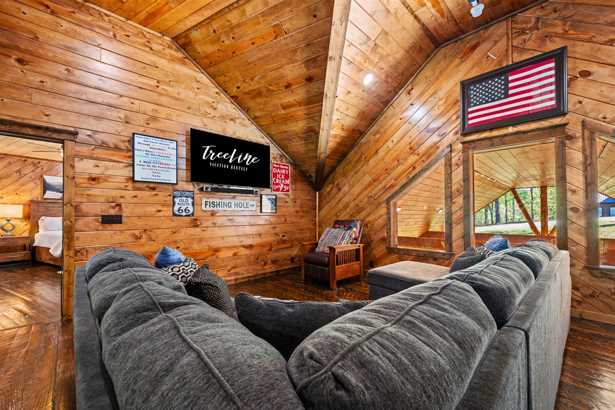 A cozy upstairs lounge creates the perfect spot to unwind, offering a comfortable setting for conversation, movie nights, or a quiet moment to yourself.