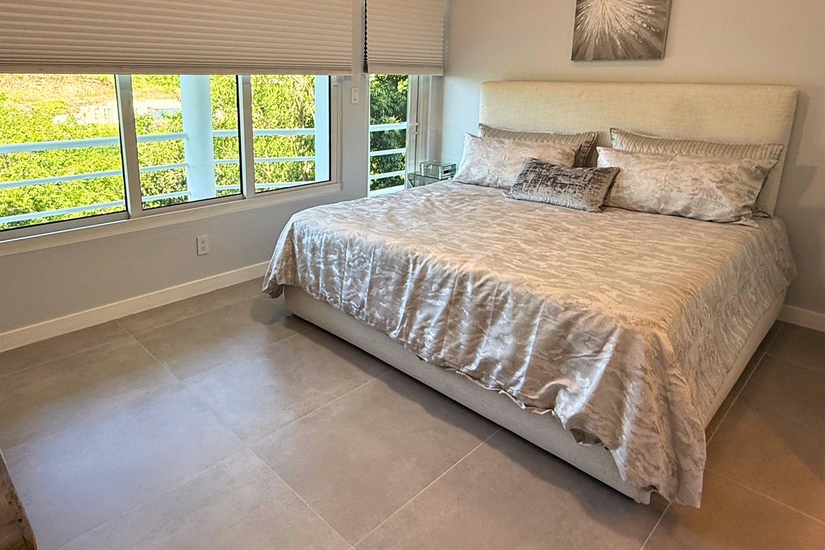 The first of two guest rooms on this level with king bed and TV