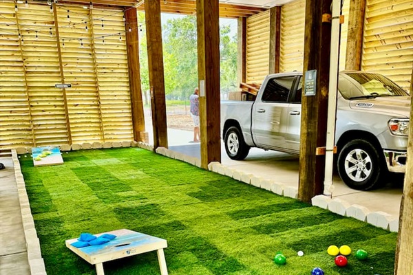 Beautiful turf Bocce Ball and Corn Hole course under the house fun outdoor games