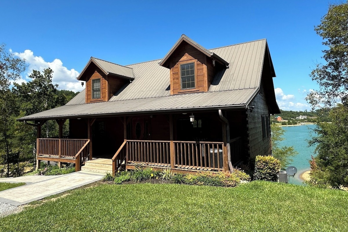 Welcome to the entrance of a genuine log cabin on Douglas Lake. This cabin has 3K sq ft of interior space, 1Ksq ft of porch space, and 2K sq ft of patio space. This cabin is on 3.8 acres and is close to Dollywood, Pigeon Forge, and Gatlinburg