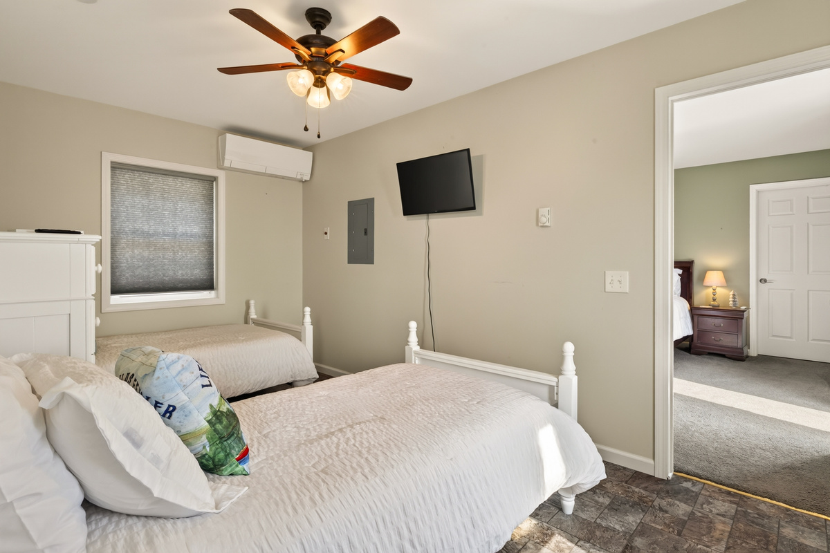 Bedroom with white bed and ceiling fan