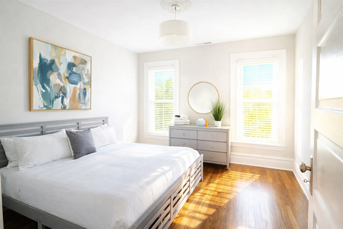 This serene guest room offers a queen bed with premium linens and a minimalist dresser for all your storage needs.