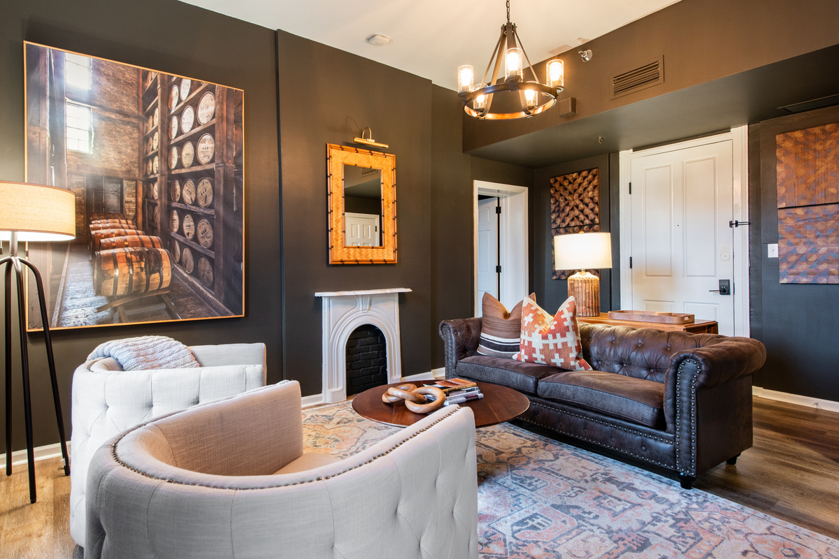The Woodford Reserve Suite living room, with leather seating and bourbon-themed artwork.