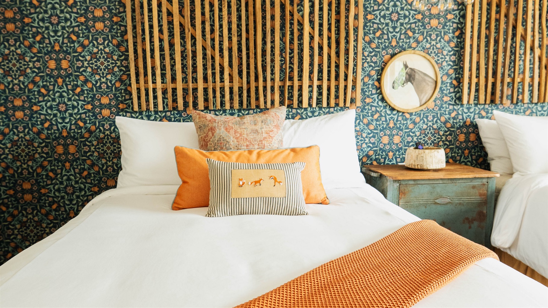 Corral Suite at Gaines Ranch on the Square — a queen bed in premium Comphy linens against a custom modern Western feature wall.