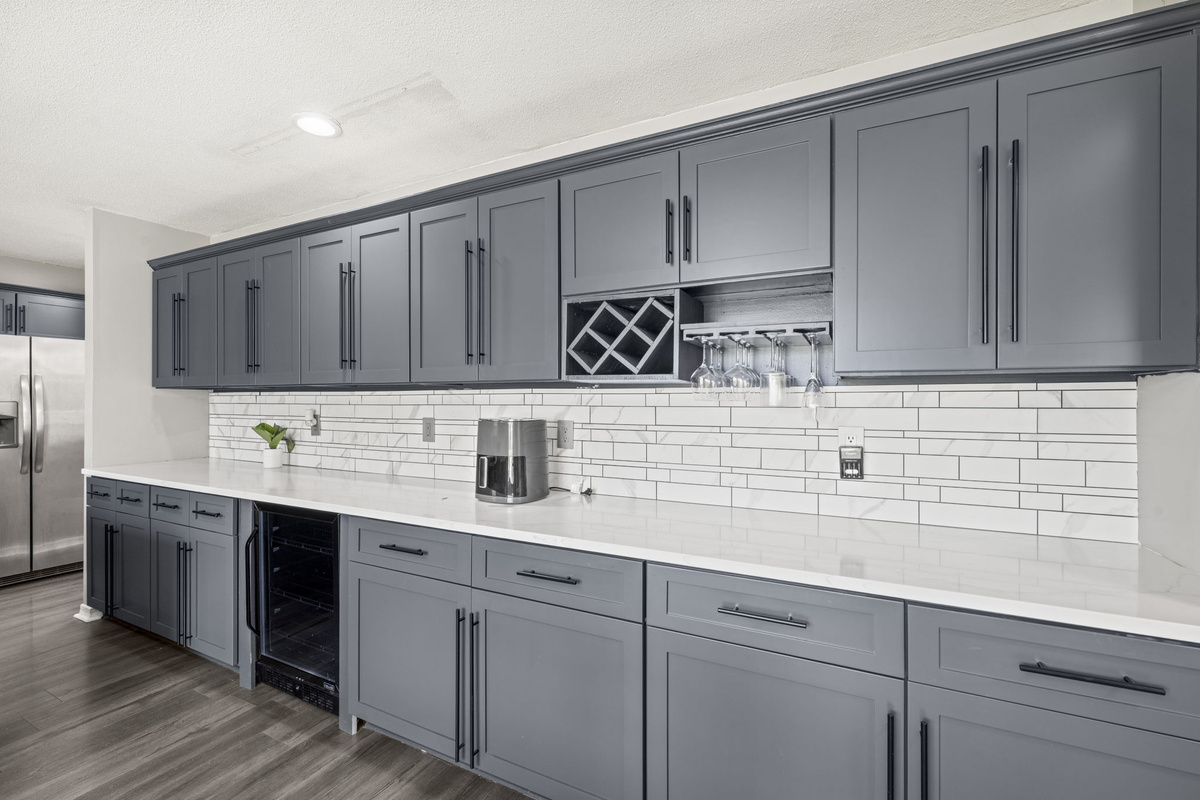 A dedicated coffee and wine station with glass racks and a built-in wine fridge — happy hour made easy.