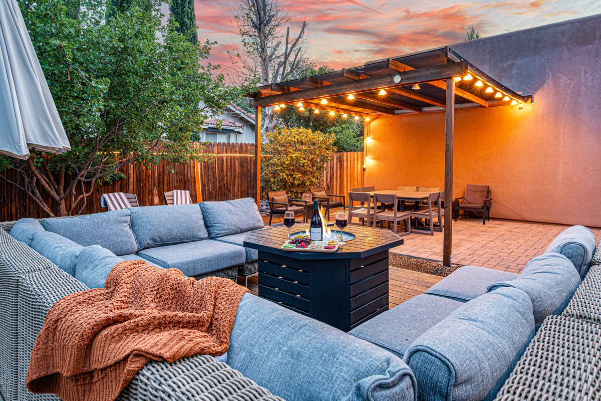 {Outdoor Lounge} Spacious outdoor seating creates an inviting place for the whole group to gather beneath the pergola and string lights.