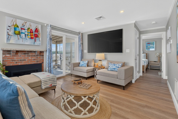 Comfortable seating, a large TV, fireplace, and plenty of natural light create the perfect gathering space.
