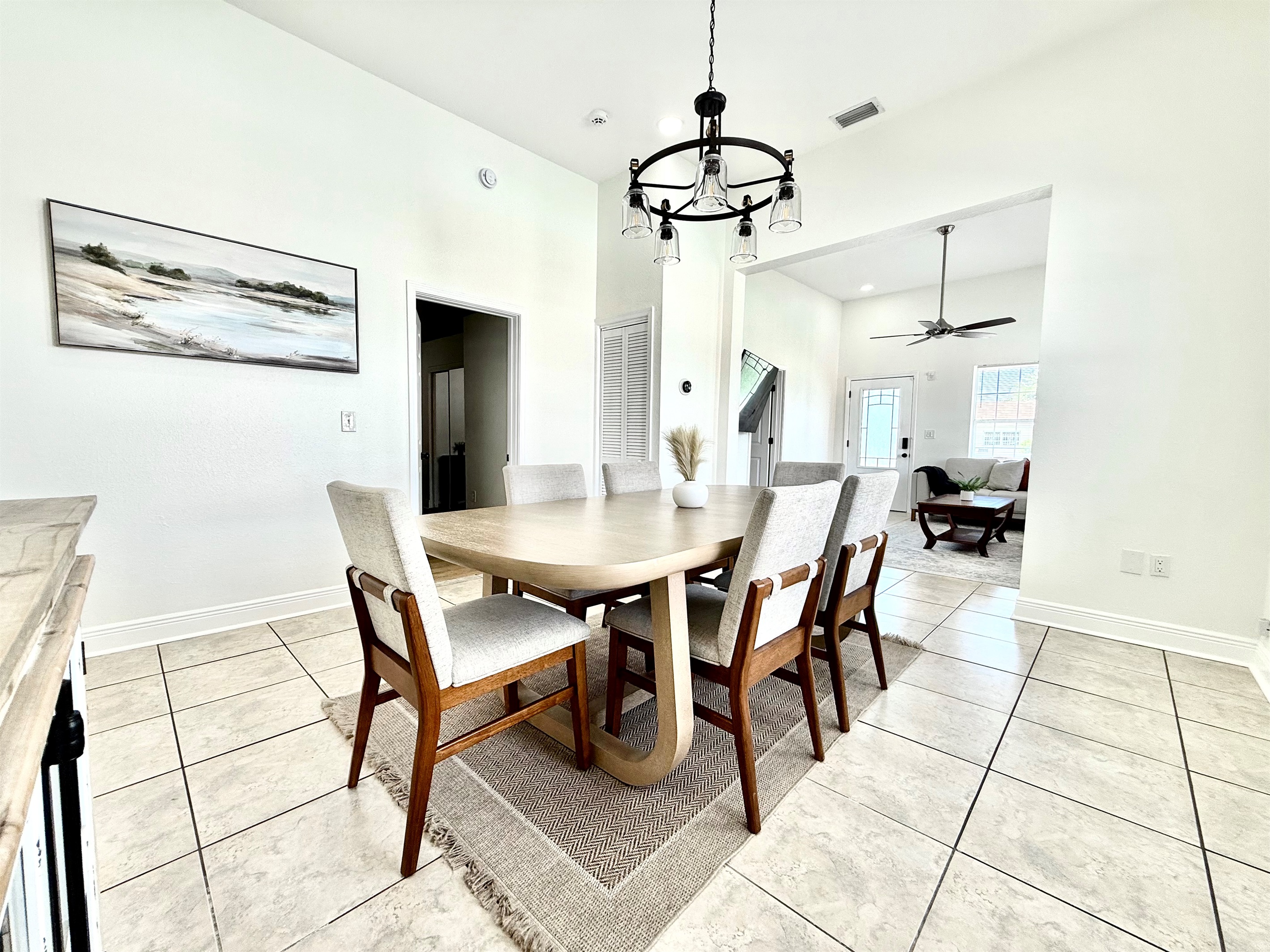 Minimalist art and modern farmhouse touches like the black chandelier add sophistication.