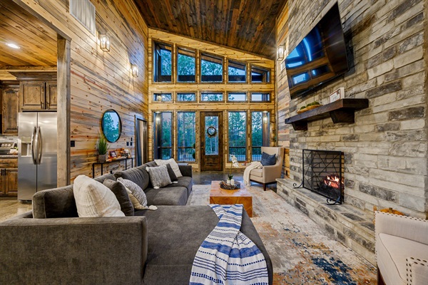 Sun-drenched living with soaring ceilings and a cozy stone fireplace.