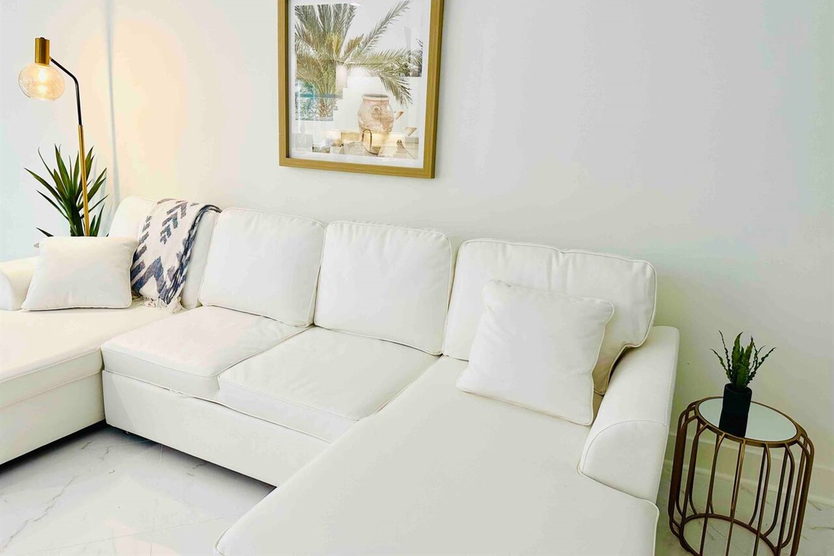White-themed living room, complete with plush sofas and a chic side lamp for the perfect balance of form.