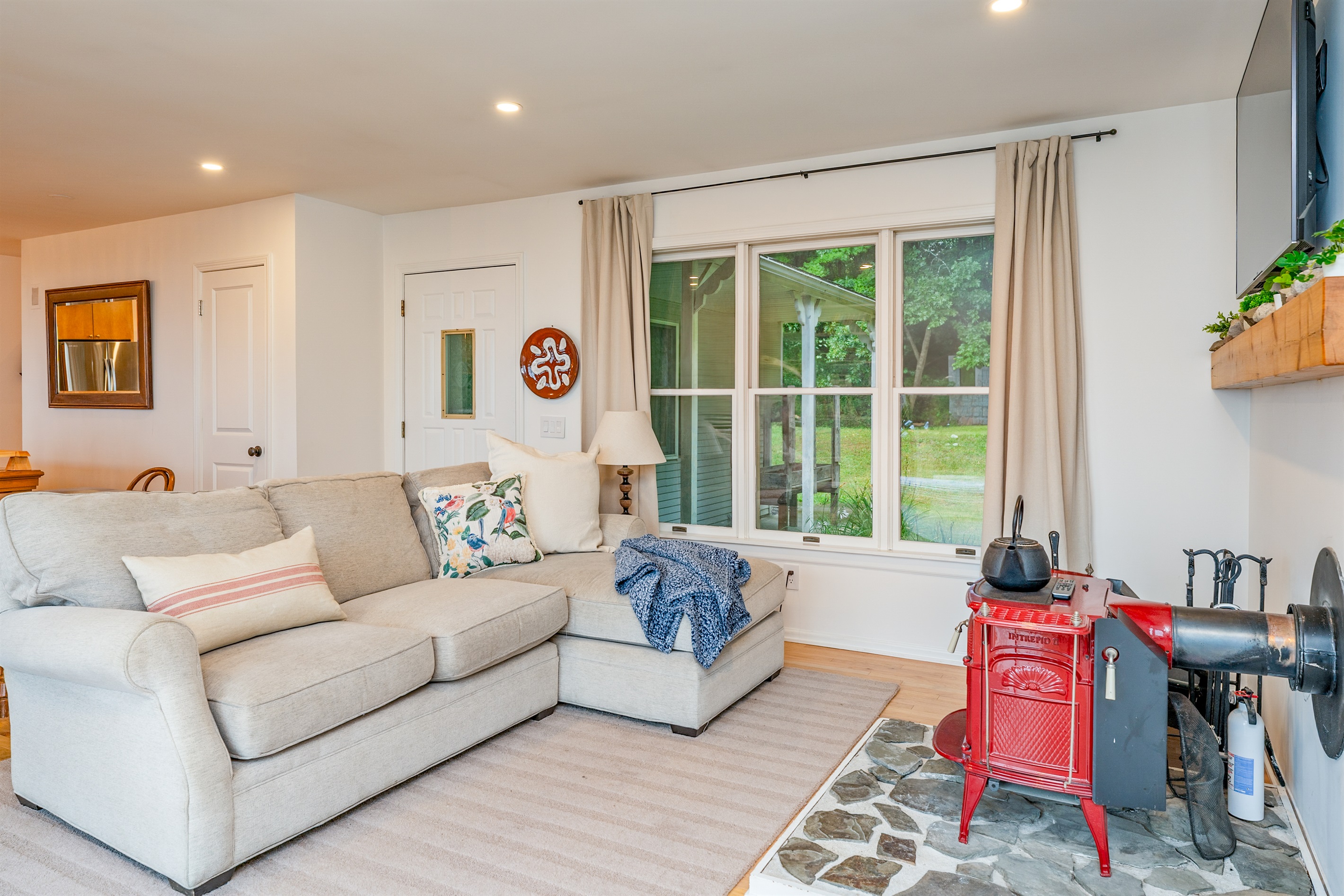 Cozy up in this charming living space featuring a plush sectional, over sized windows for ultimate comfort.