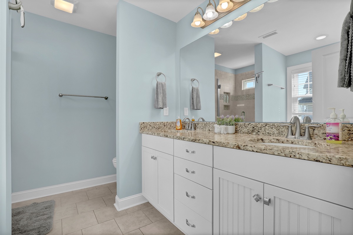 Expansive vanity with granite counters, providing plenty of room for everyone to get ready.