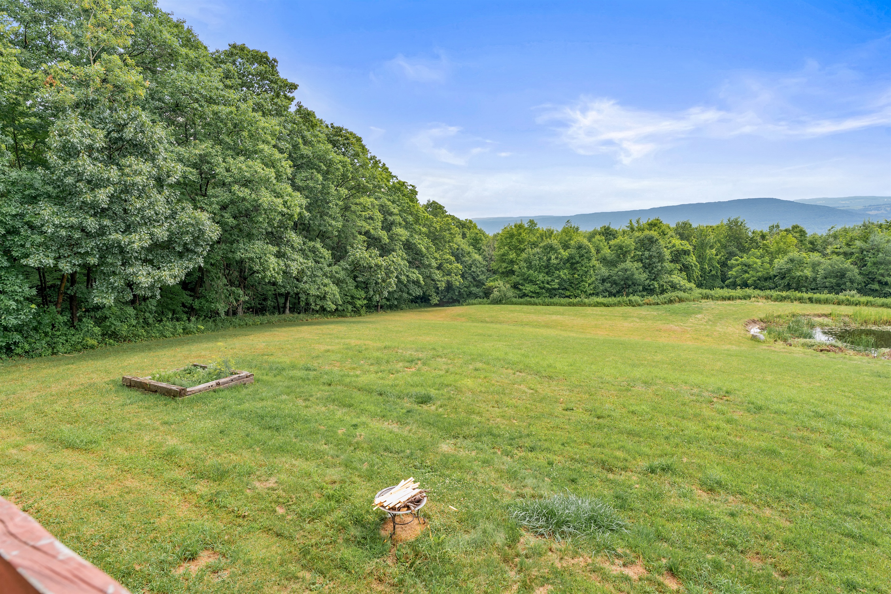 Enjoy endless space to roam with open grassy fields and a tree-lined backdrop ideal for outdoor fun and relaxation