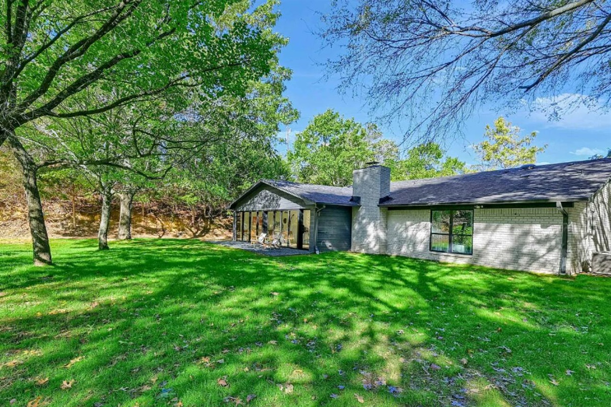 Backyard view showing open green space, tree canopy, and peaceful natural surroundings ideal for outdoor relaxation.