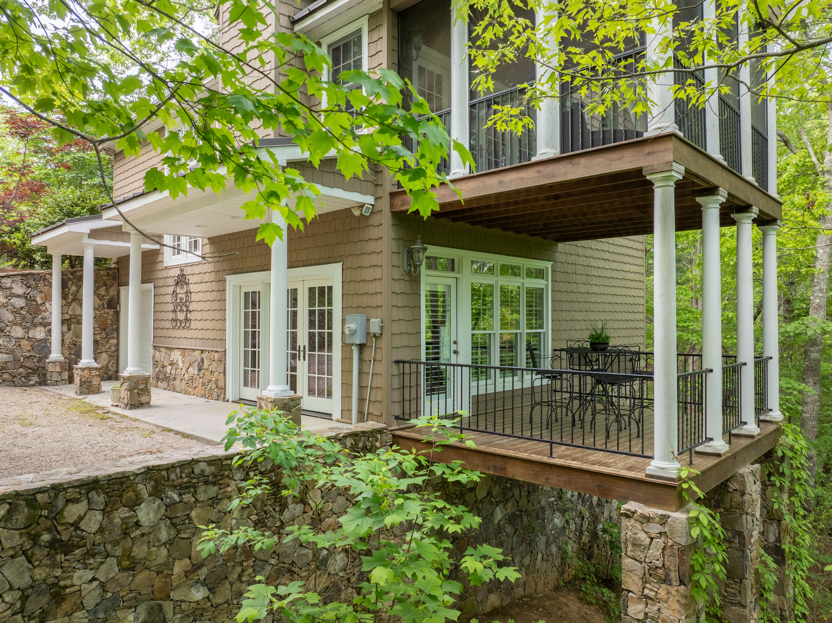 Enjoy peaceful wooded surroundings from the private lower-level covered deck just outside the guest suite.