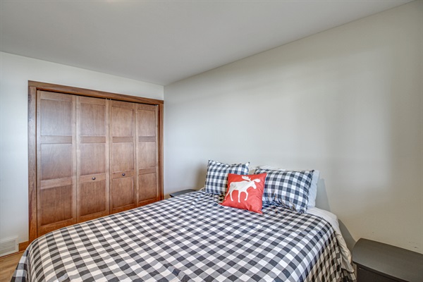Lower-level bedroom with queen bed and large closet space