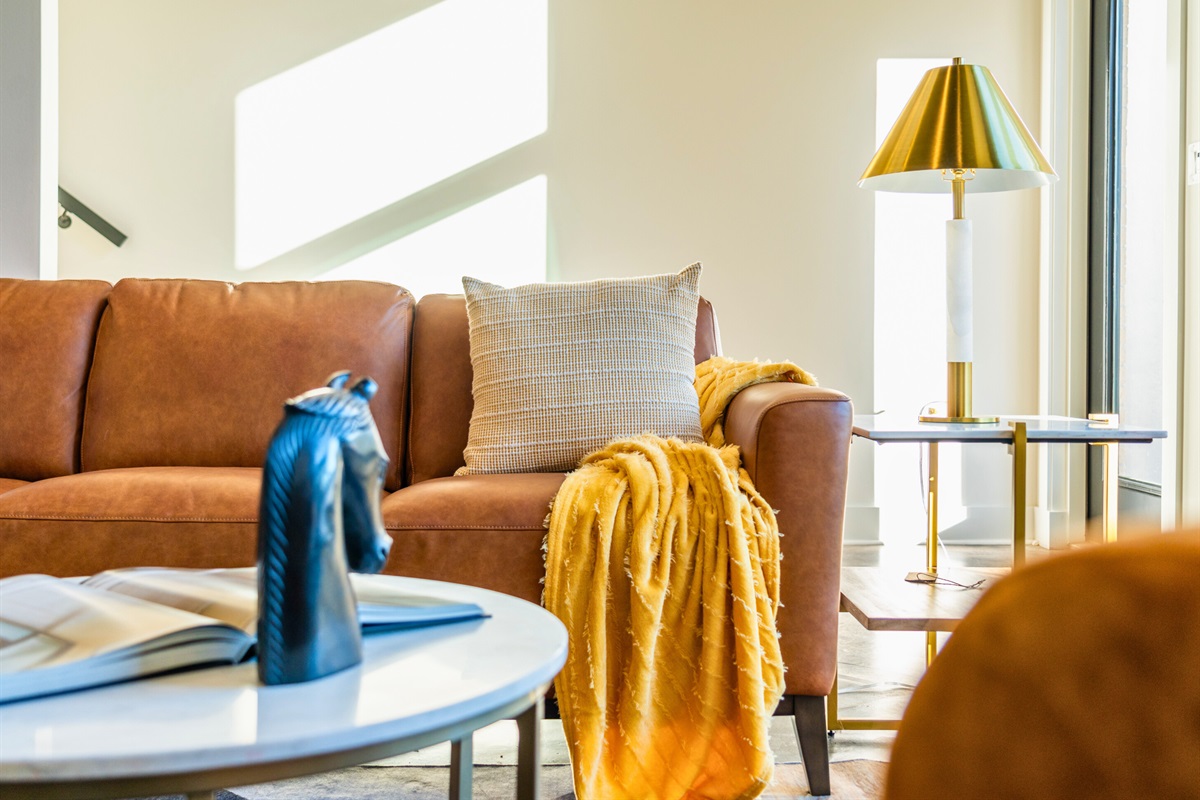 This cozy seating area, bathed in natural light, blends warm tones and contemporary decor to create the perfect spot for relaxation and conversation.