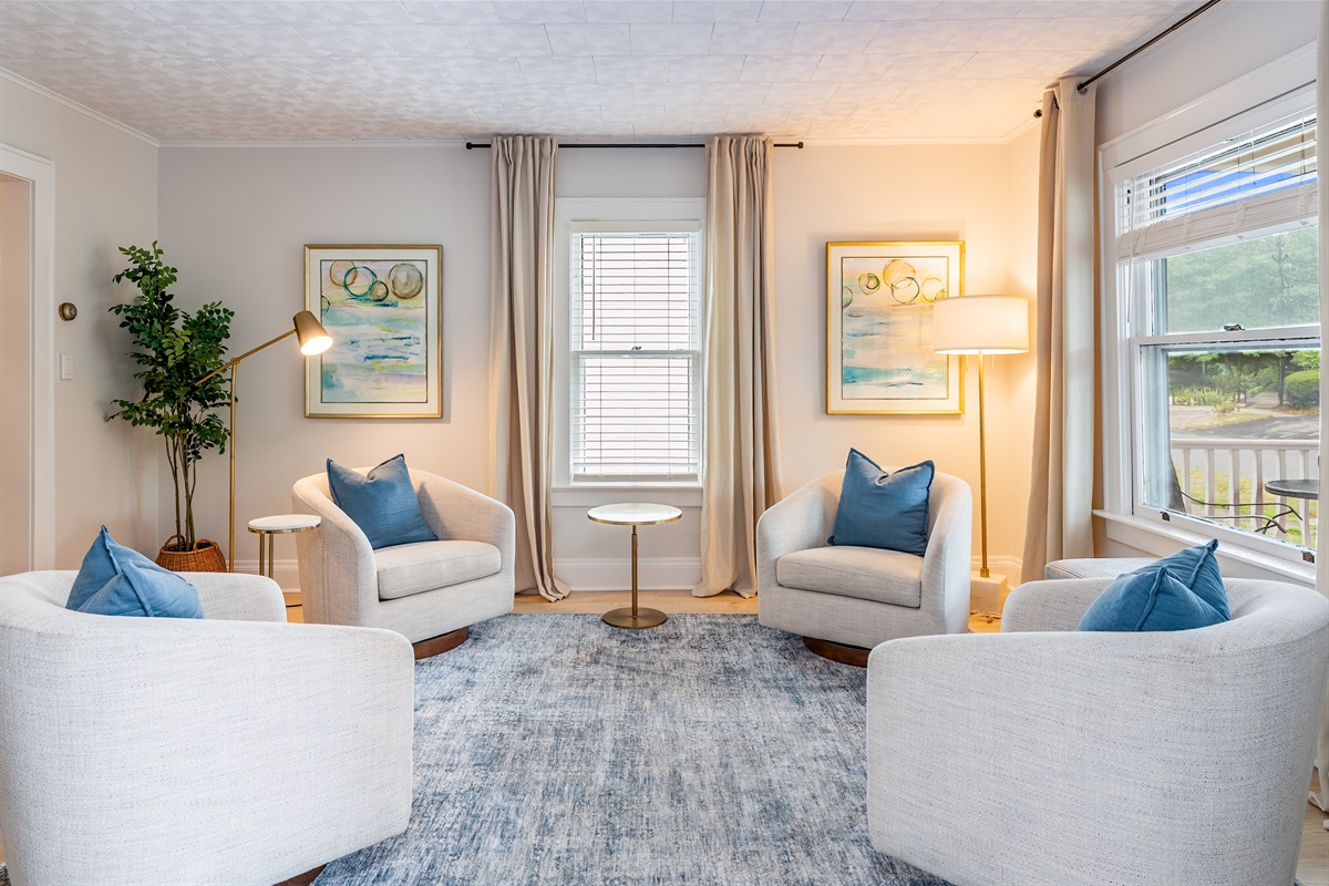 Stylish and serene, this window-wrapped living room lets in natural light and showcases designer seating with calming décor.