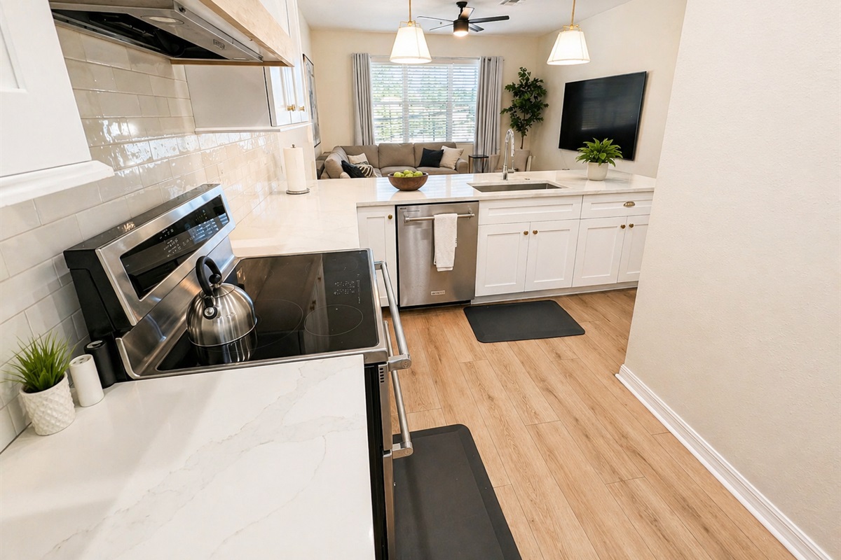 Bright and modern kitchen with sleek countertops, stainless steel appliances, and plenty of prep space. Open layout flows into the living area, making it easy to cook, dine, and stay connected with guests.