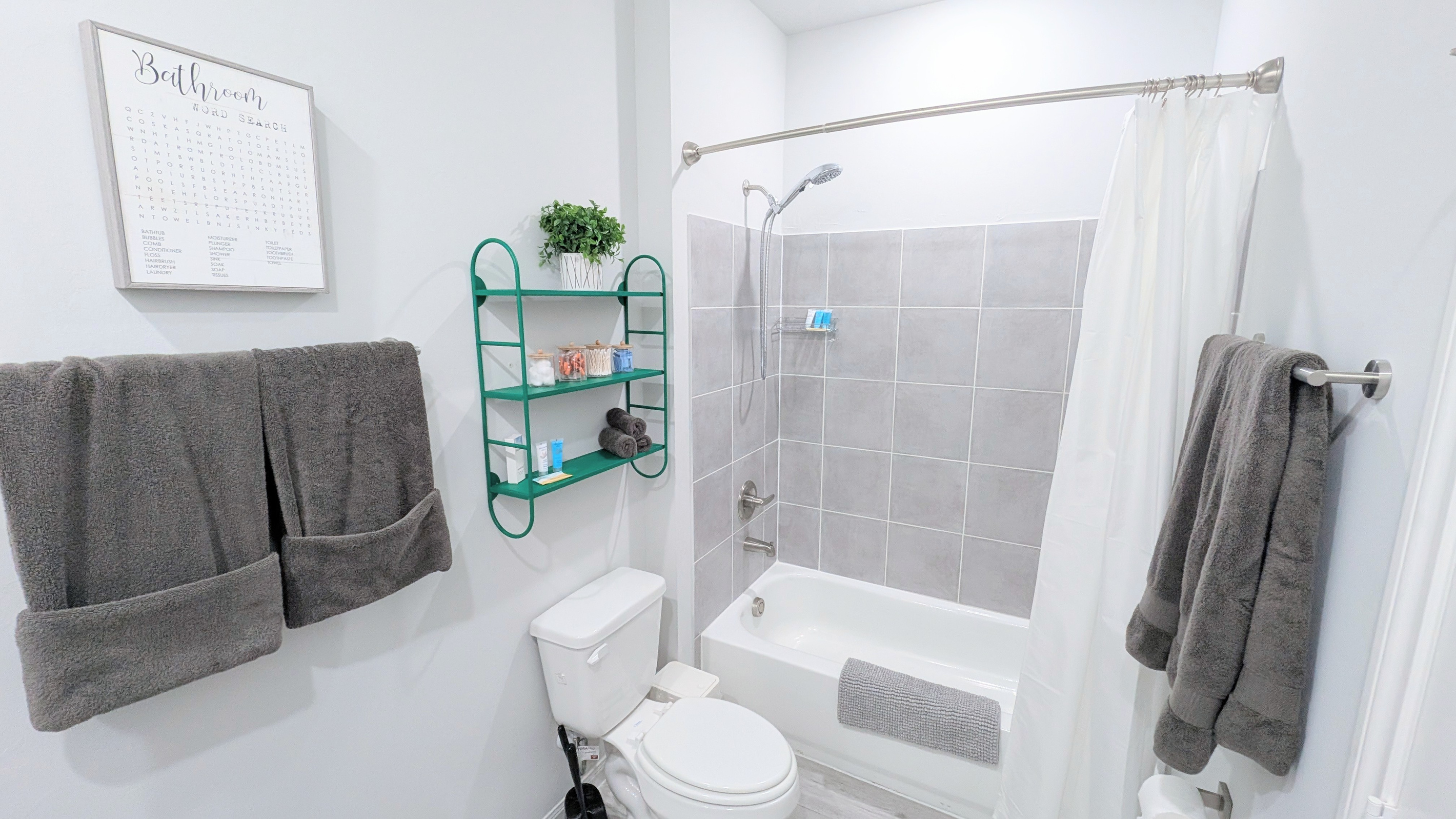 En suite bathroom located off the primary bedroom is fully stocked with fluffy towels, basic toiletries, and all the comforts of home. 