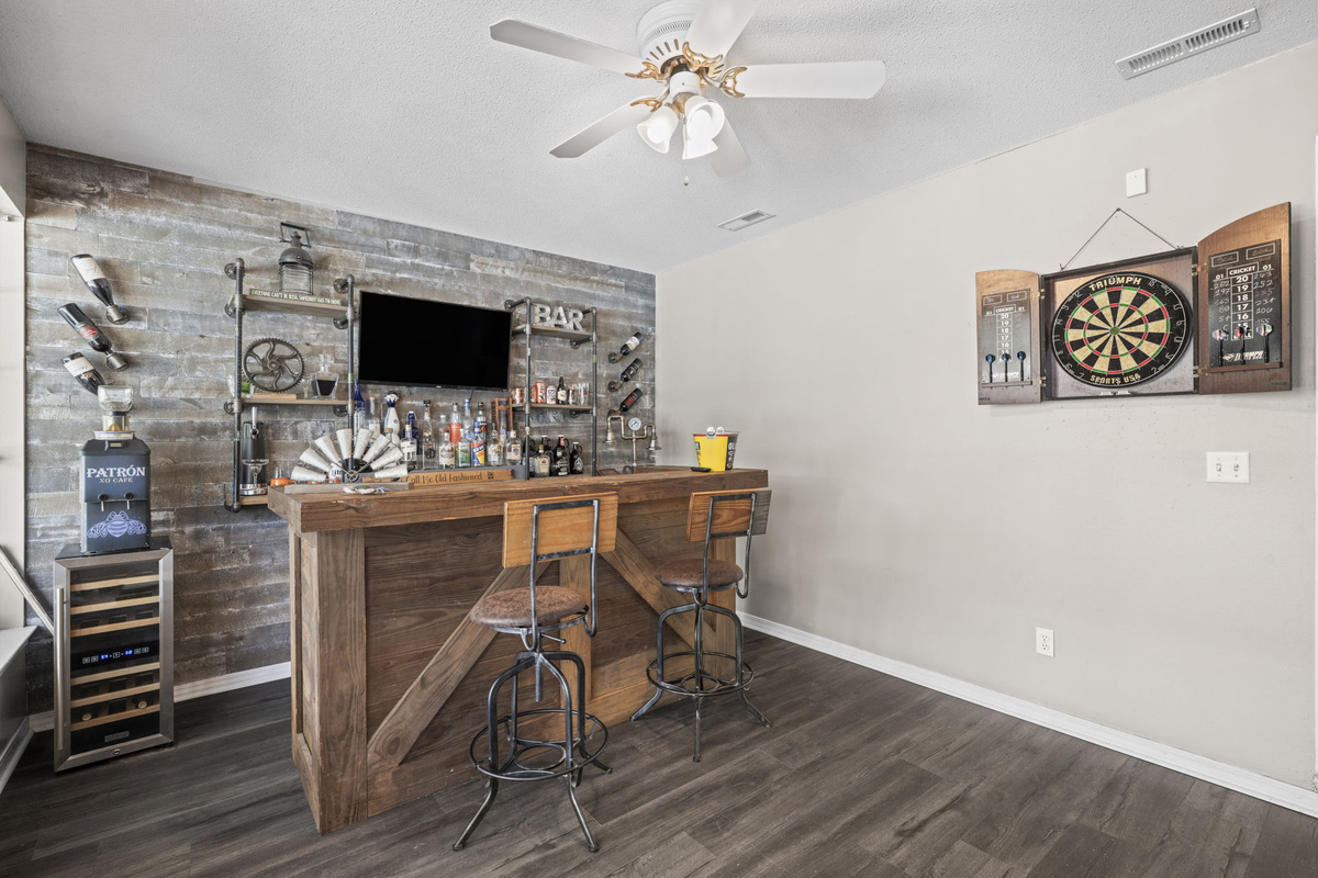Bar seating meets a dartboard setup for casual entertainment — a fun hangout spot beyond the main living area.