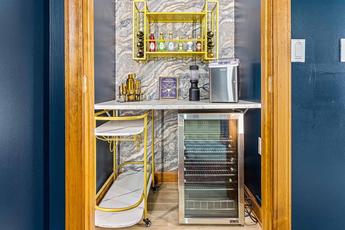 Our speakeasy-style lounge features a chic bar nook, complete with a wine fridge, ice maker, and gold accents — the perfect place to mix a cocktail before stepping out to the firepit.