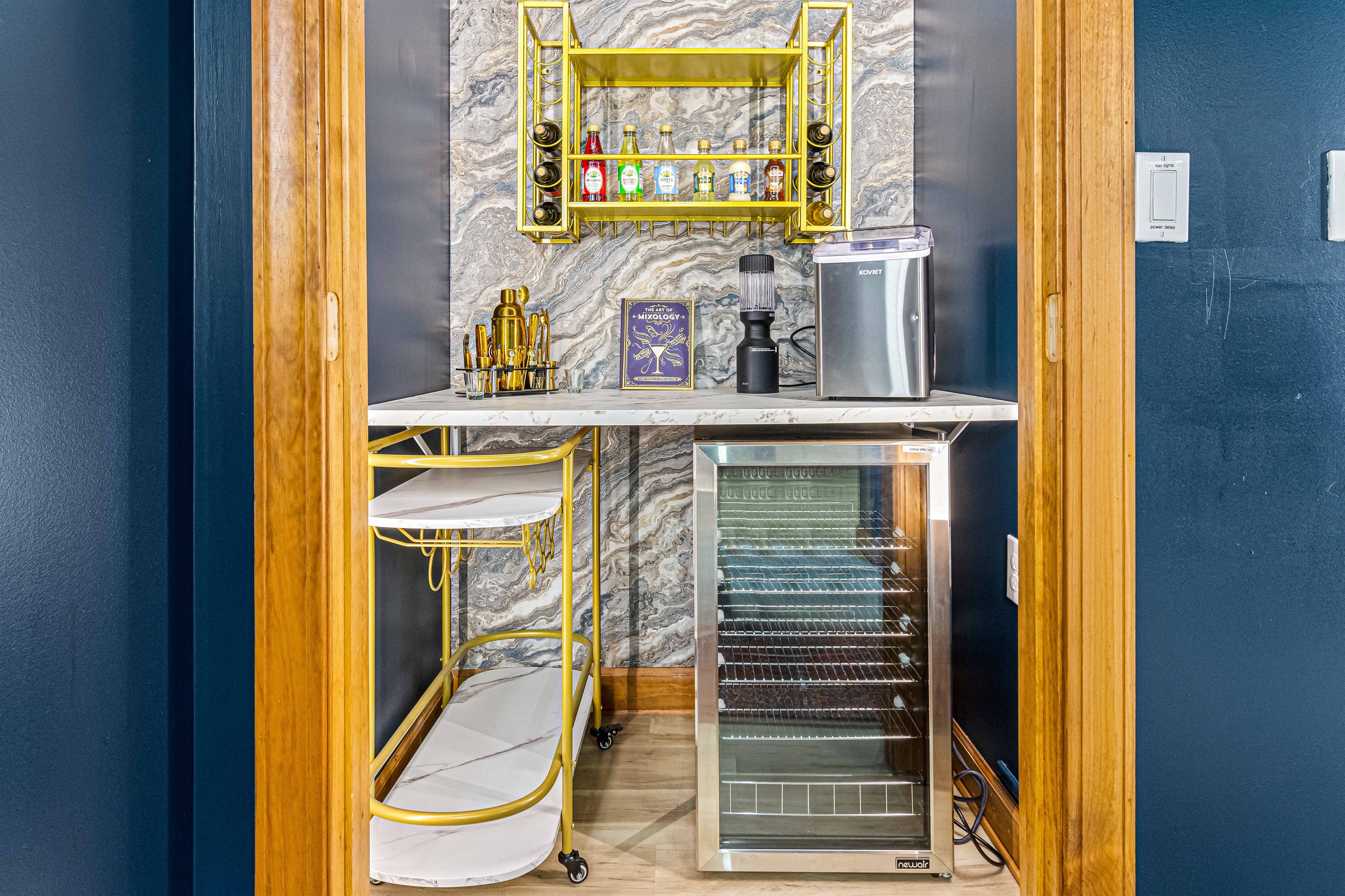 Our speakeasy-style lounge features a chic bar nook, complete with a wine fridge, ice maker, and gold accents — the perfect place to mix a cocktail before stepping out to the firepit.