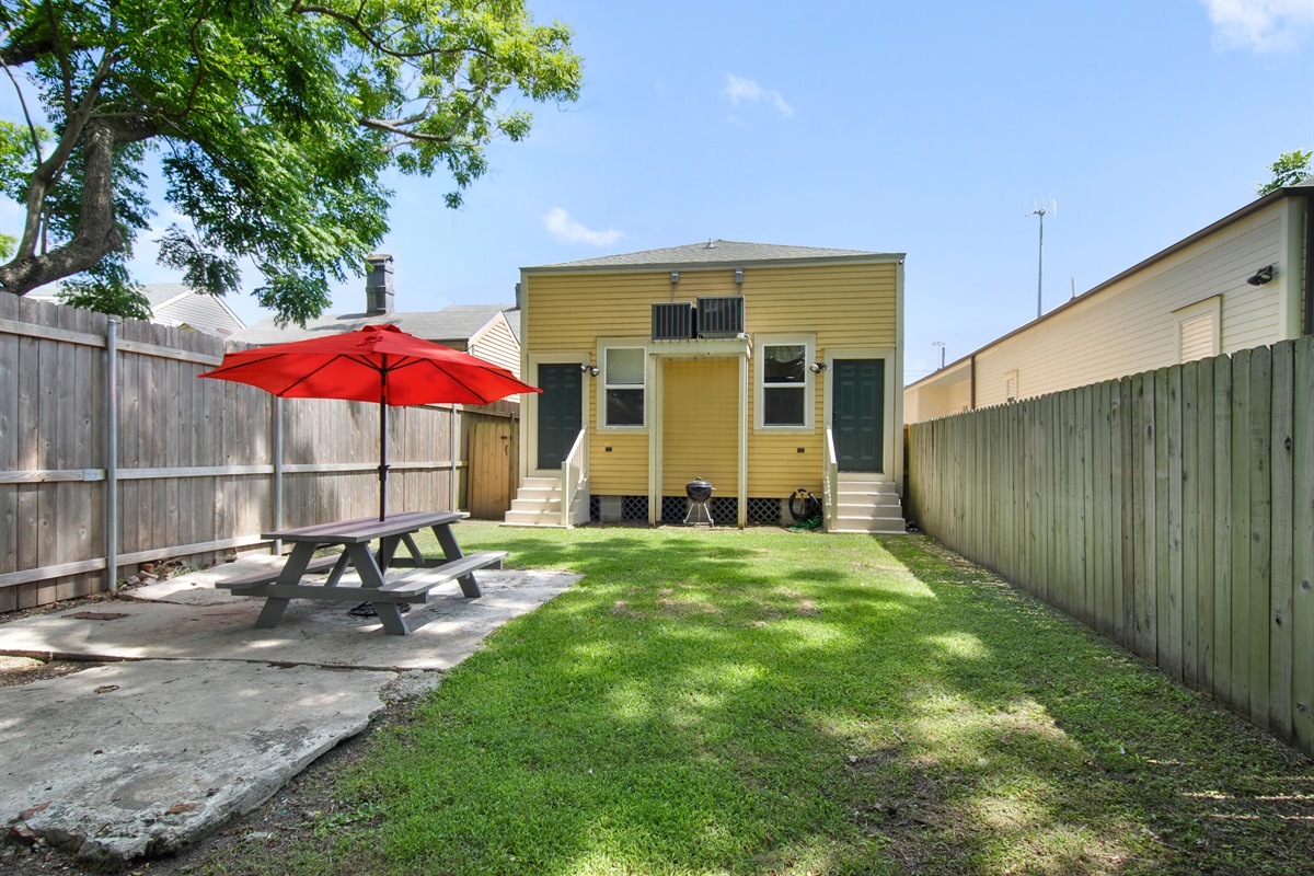Backyard shared with neighboring guests.  Seating and charcoal grill.