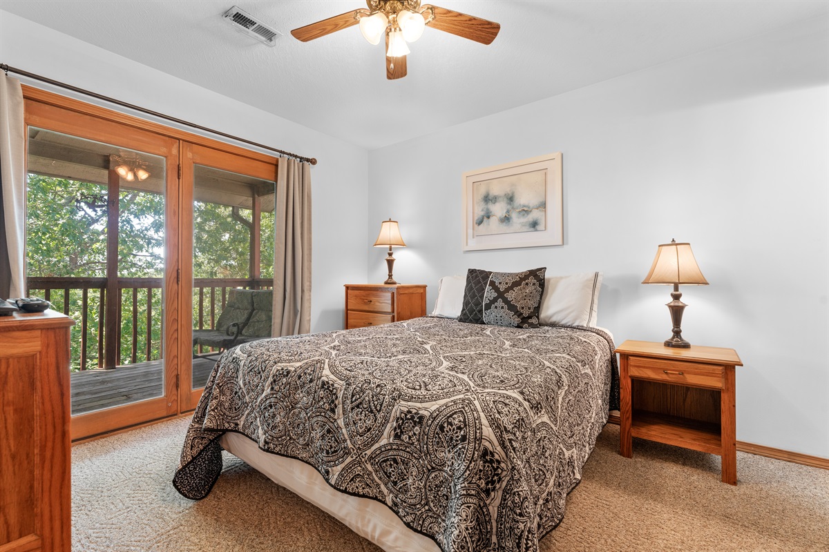 Wake up in the primary bedroom and step straight out toward the deck and trees beyond.