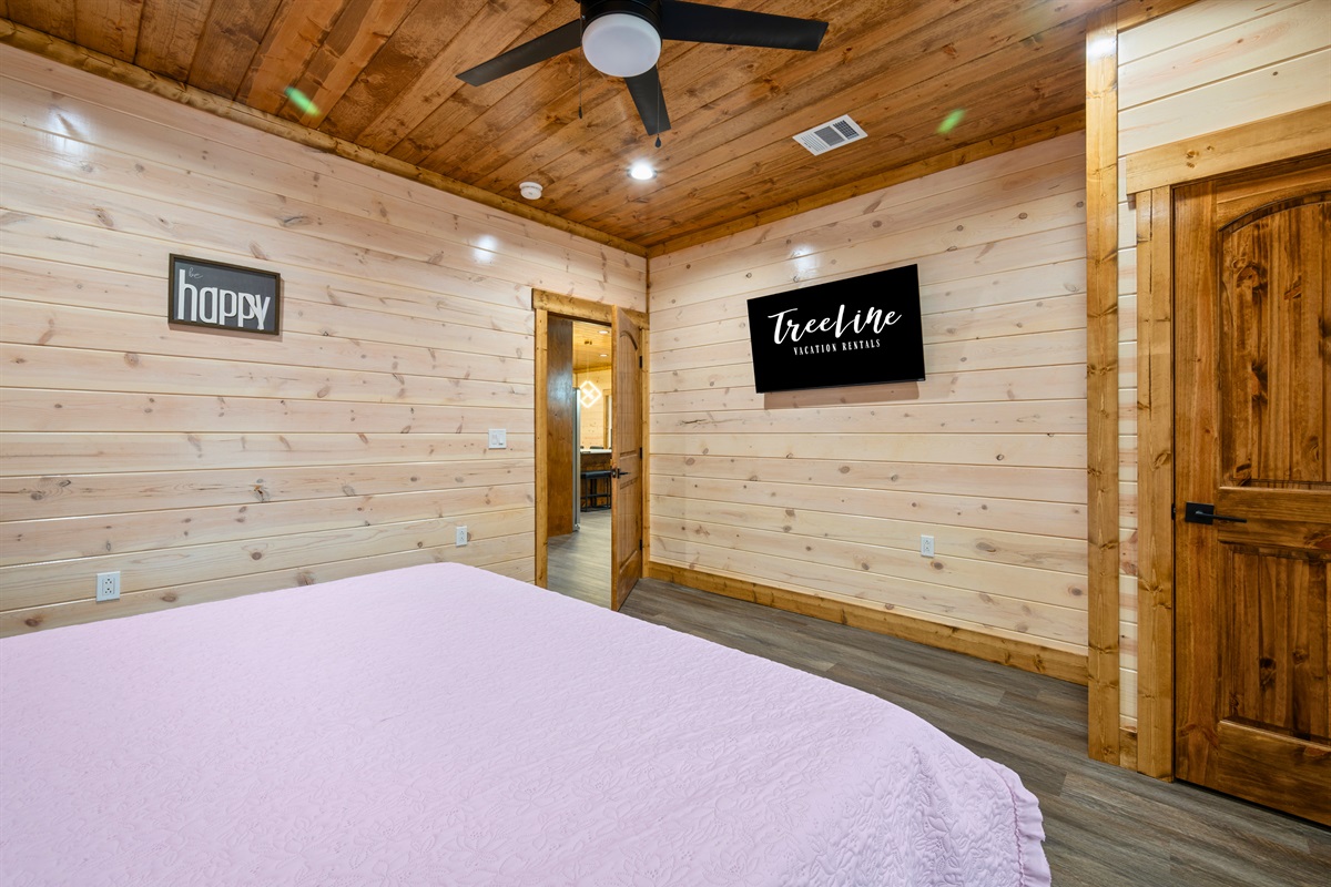 From another angle, the king bedroom feels especially calm and welcoming, with a plush bed, simple décor, and the cozy cabin atmosphere that makes it easy to relax.