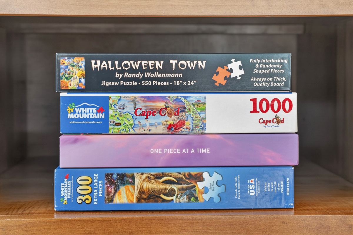 Collection of classic board games and puzzles neatly displayed on wooden shelving, perfect for cozy family game nights and indoor entertainment.