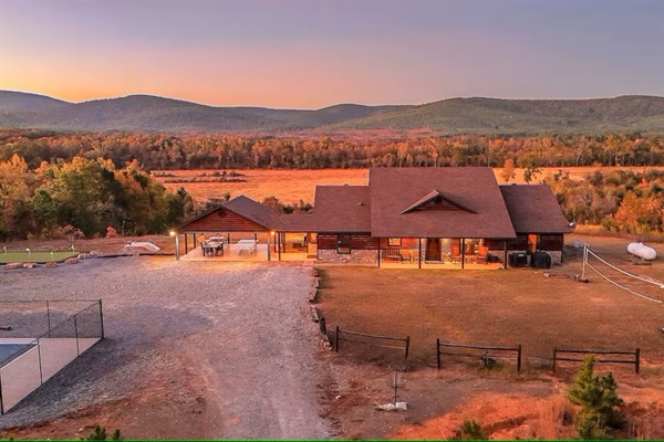 Wide aerial showing driveway, decks, and outdoor amenities.