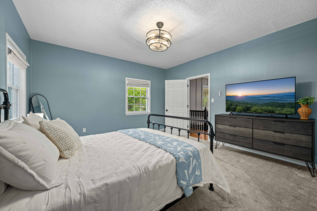 Bedroom Retreat: Bright walls and stunning views invite relaxation and restful nights on plush bedding!