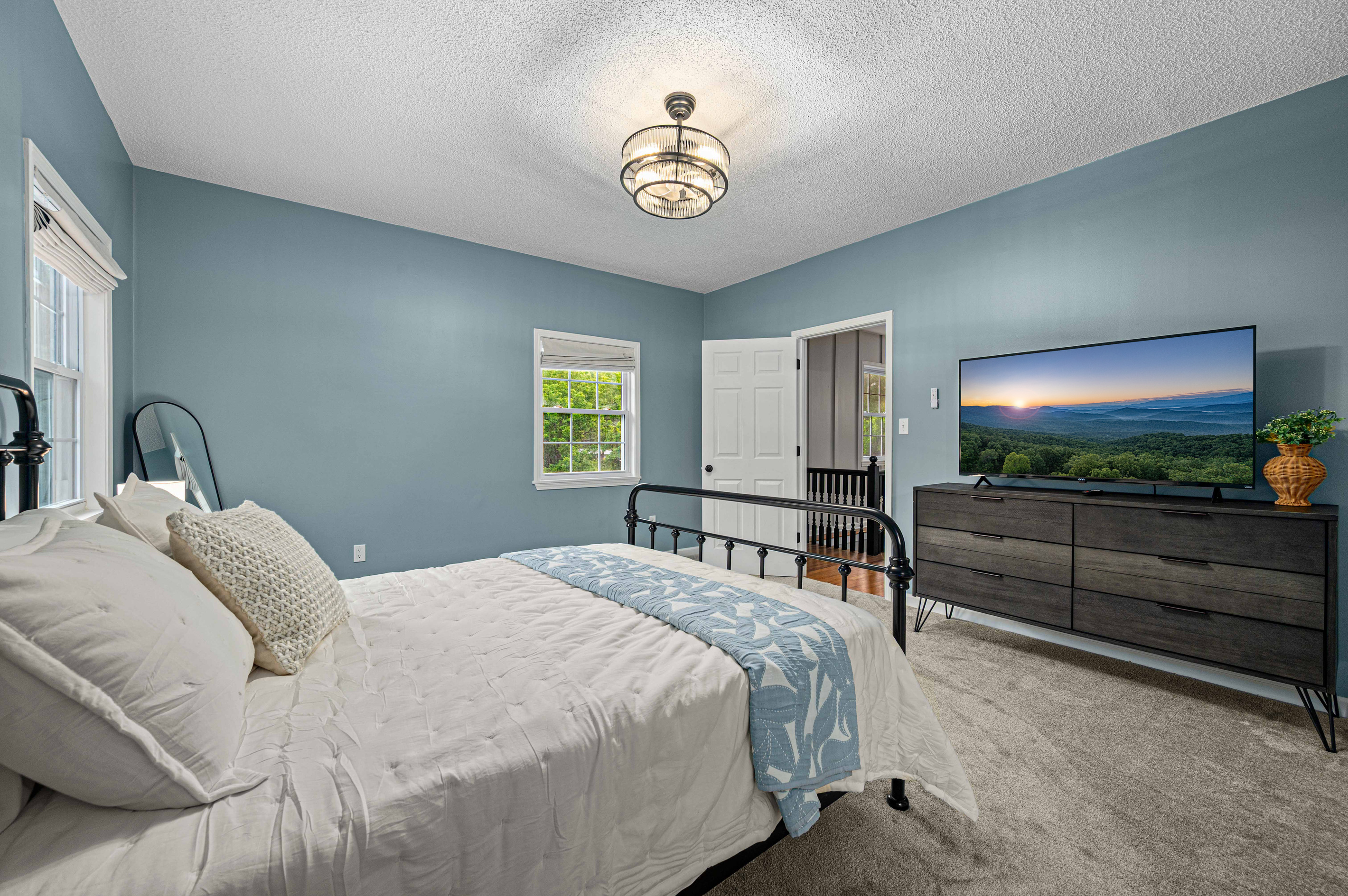 Bedroom Retreat: Bright walls and stunning views invite relaxation and restful nights on plush bedding!
