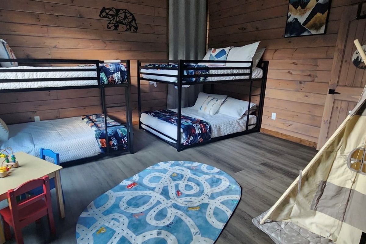 Family-friendly kids’ room with bunk beds, toy table, and cheerful vibes.