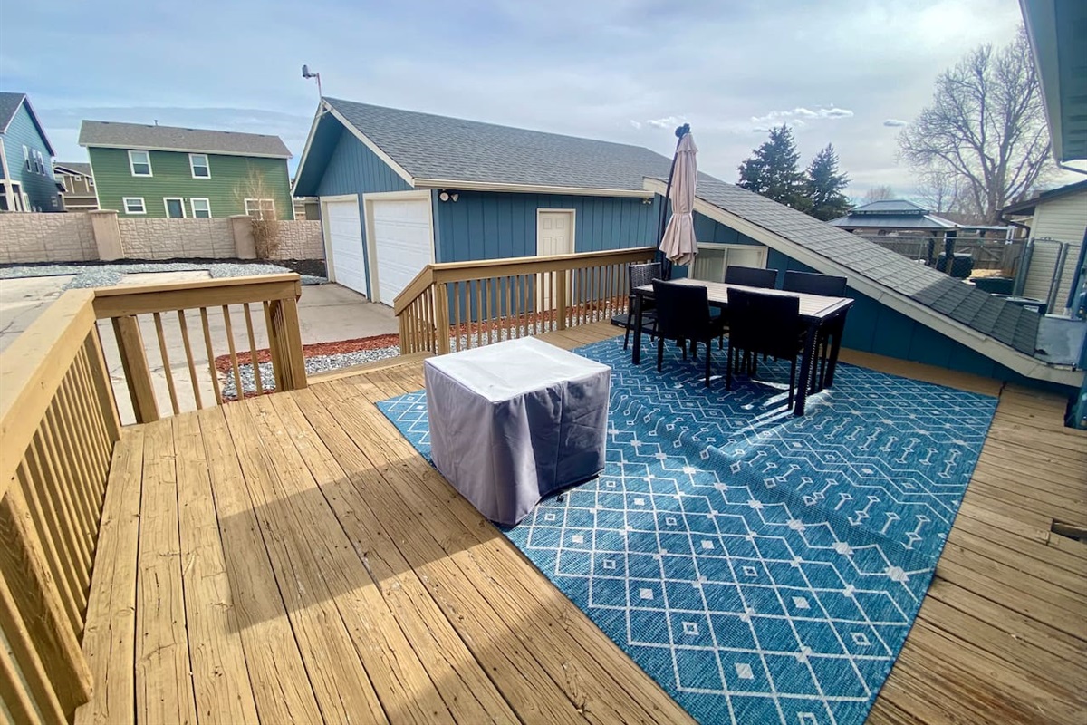 Private, fully-fenced backyard with fire pit, grill, and dining table.