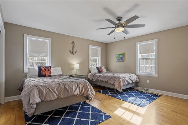 Bright and spacious bedroom with two double beds, dual closets, TV, and Desk/chair.