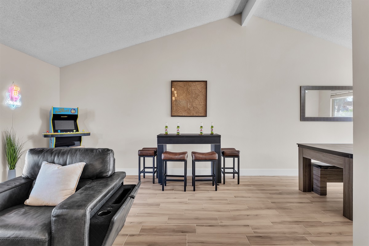 Living room 1 with 86 inch tv, simpsons arcade, bar table that converts to roulette and craps. Connects to dining room.