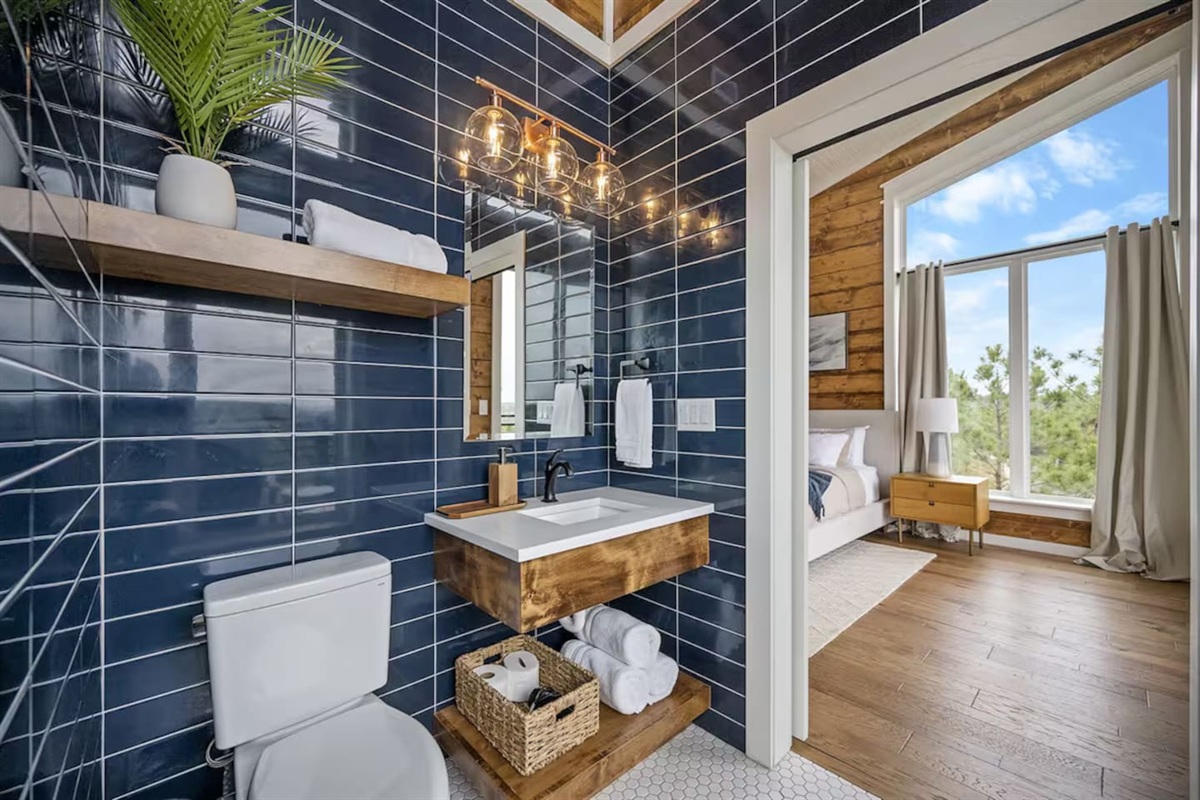 Full bathroom with shower, vanity, and wood finishes.