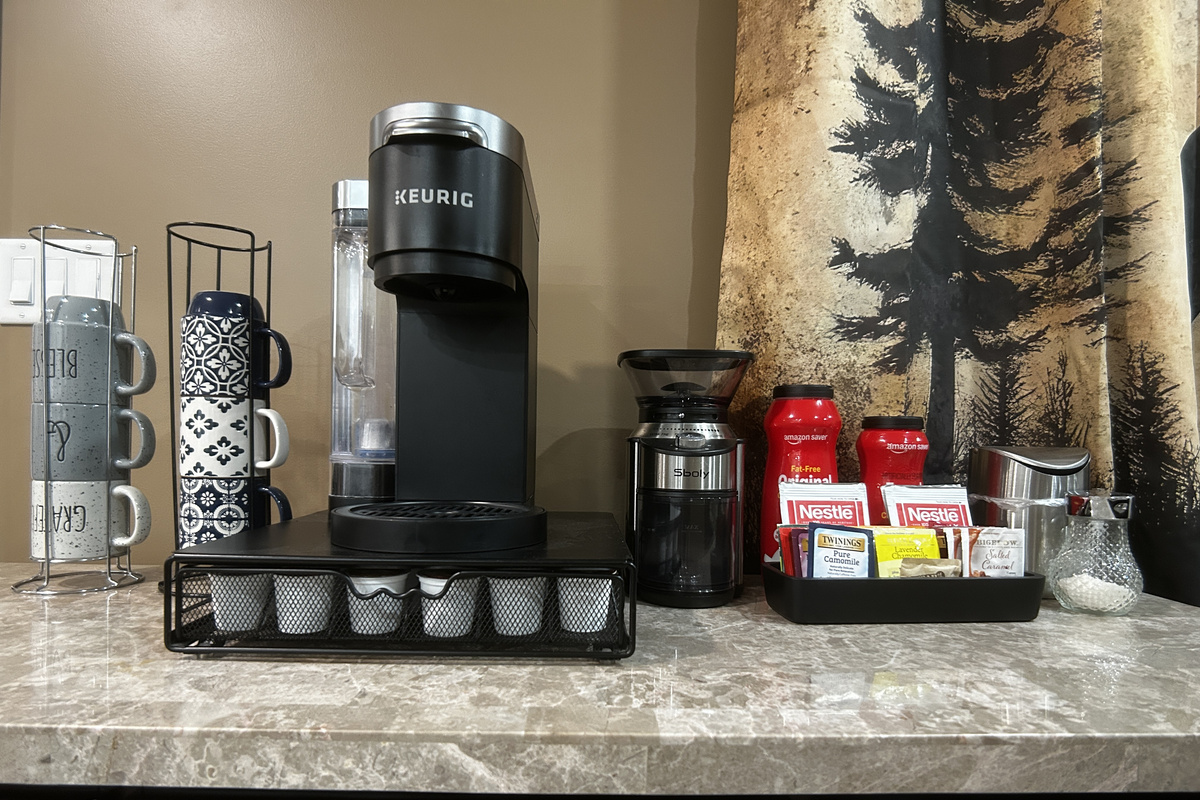 Coffee/tea bar with coffee grinder. Bar has some coffee and tea to get you started until you go grocery shopping. There is also sugar and powdered creamer.