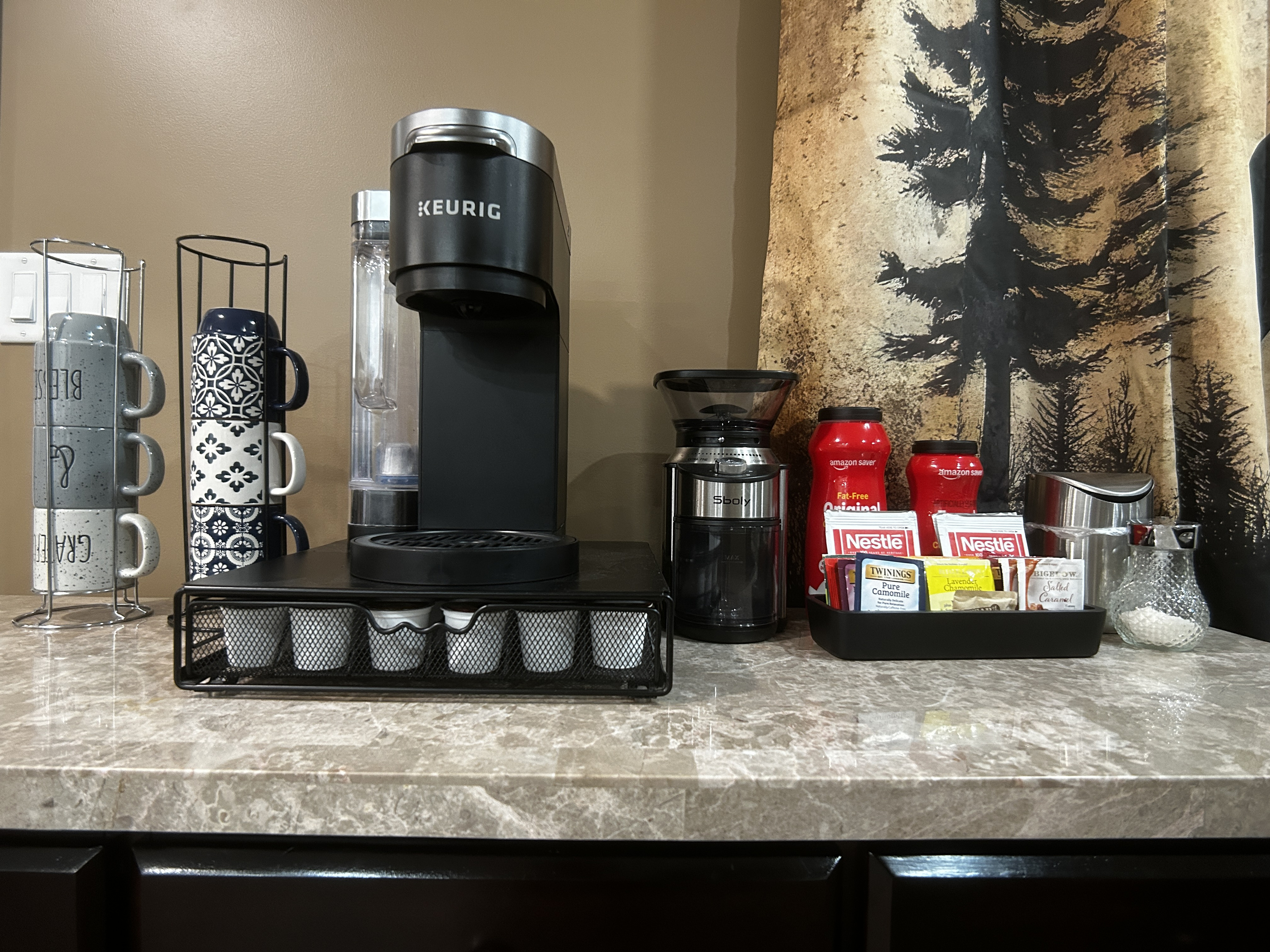 Coffee/tea bar with coffee grinder. Bar has some coffee and tea to get you started until you go grocery shopping. There is also sugar and powdered creamer.