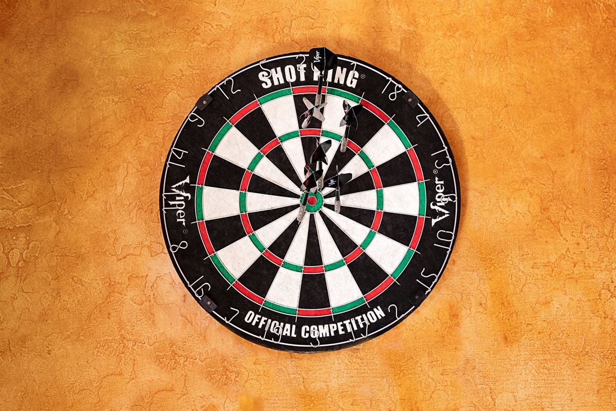 Challenge your aim and enjoy some friendly competition with this classic wall-mounted dartboard set against warm textured walls.