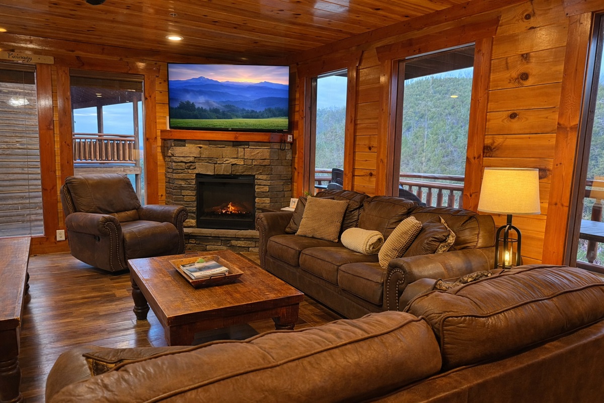 Thoughtful design meets mountain luxury in this inviting family room with cozy seating, a glowing fireplace and mountain views.