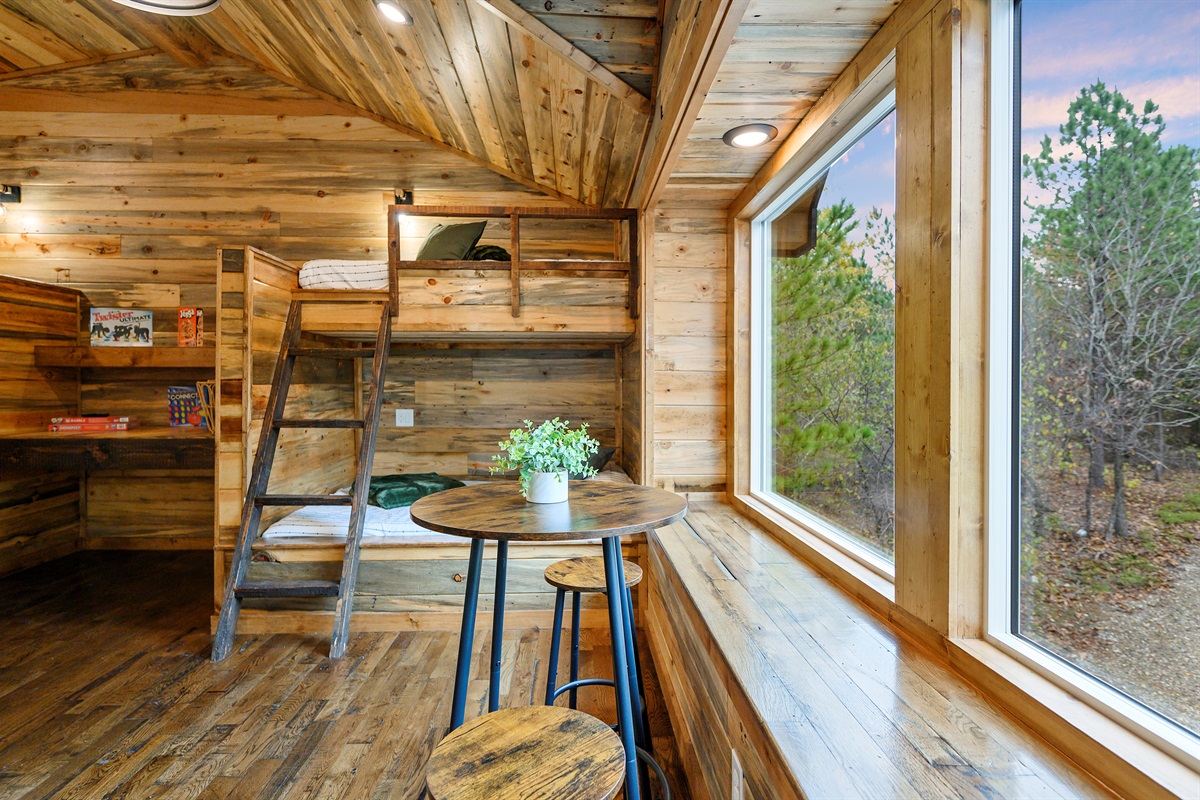 The upstairs bunk loft at Hit Refresh comes with its own little gathering spot. 
A tucked away table for card games, late night chats, and those quiet cabin moments in between all the fun upstairs.