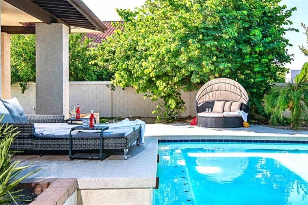 Lounge in style beside the heated pool surrounded by greenery, luxury seating, and total backyard bliss.