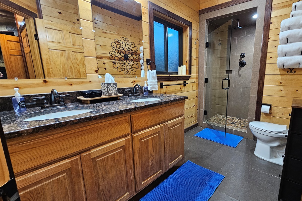 Enjoy a touch of luxury in the spacious primary bathroom featuring a double vanity and a walk-in rain shower.
