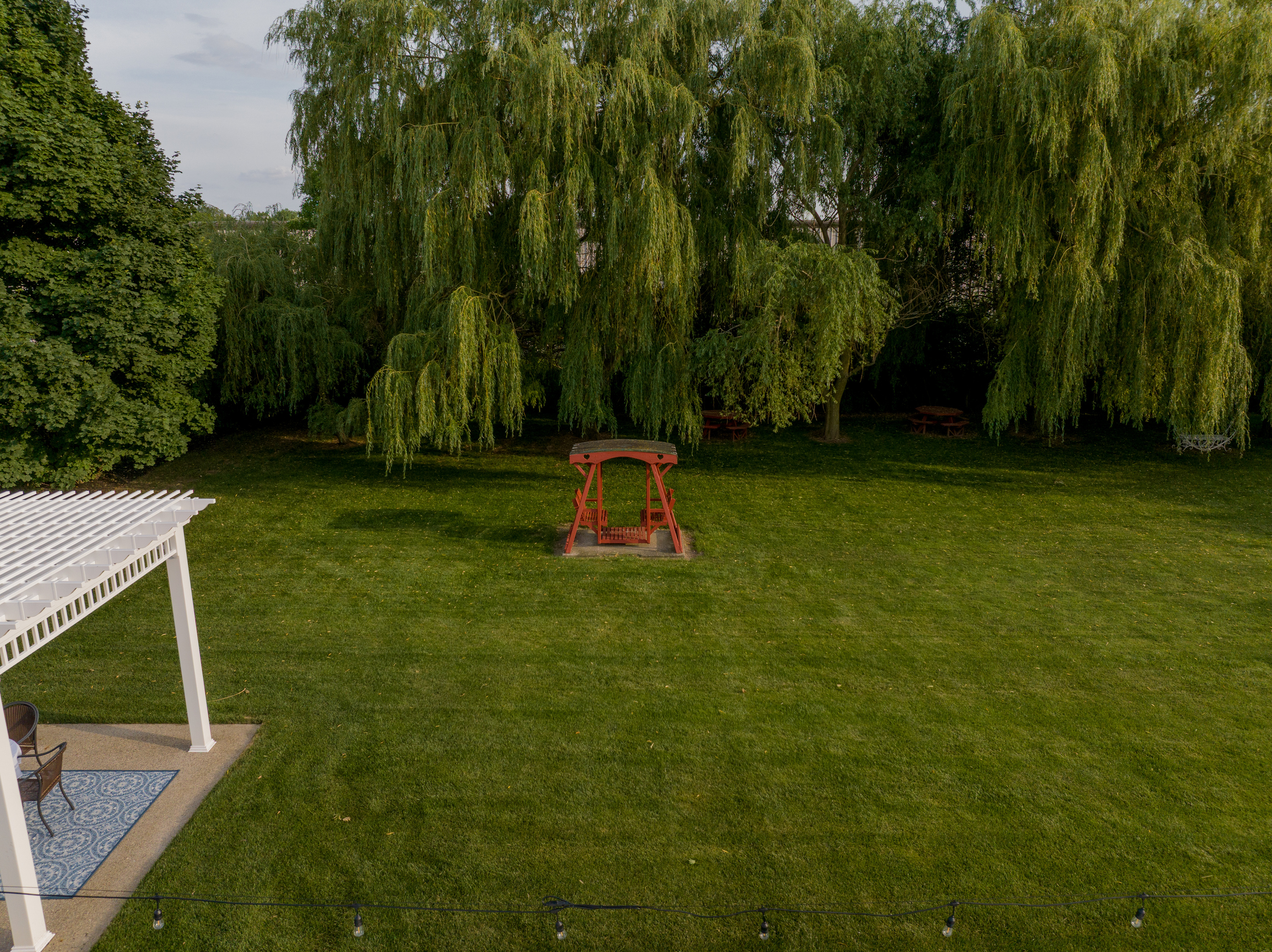Relax beneath the shade of majestic weeping willow trees while enjoying peaceful garden views, comfortable seating areas, and fresh Lake Erie breezes