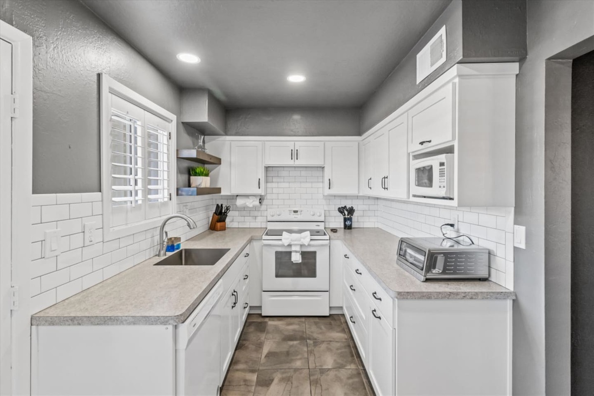 Kitchen with white cabinets, full appliances, and plenty of counter space for easy meals.