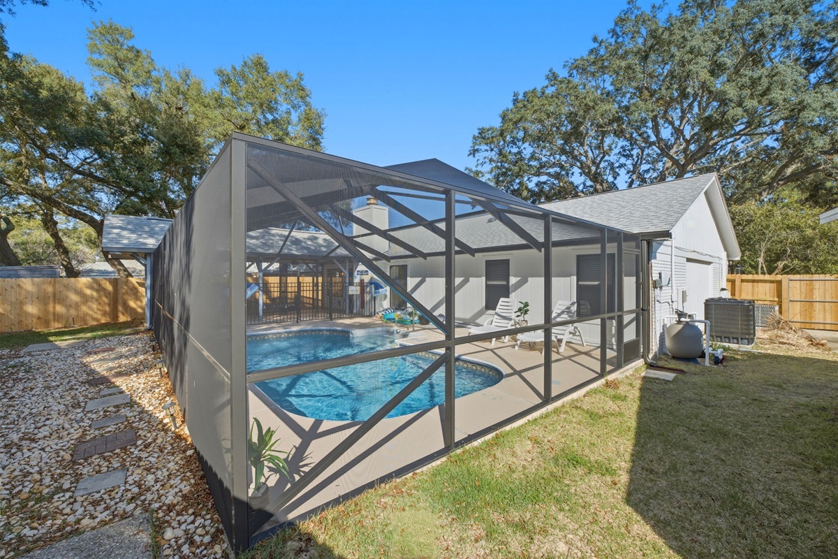 The screened lanai surrounds a beautiful pool, allowing you to enjoy fresh air and sunshine while staying comfortable. With poolside loungers and plenty of open space, it’s a perfect place to relax and recharge during your stay.